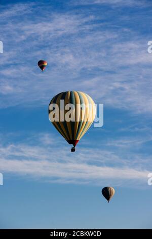 Trois ballons d'air chaud flottant contre le ciel bleu, parc national de Göreme, Cappadoce, Anatolie, Turquie Banque D'Images