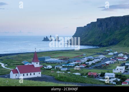 Vue panoramique sur les piles de la mer de basalte de Reynisdrangar et le village de Vik, Myrdalshreppur, Islande Banque D'Images