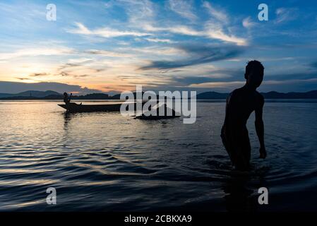 Guwahati, Assam, Inde. 14 août 2020. Pêcheur rangée son bateau comme un homme prenant le bain dans la rivière Brahmaputra au coucher du soleil à Guwahati. Crédit : David Talukdar/ZUMA Wire/Alay Live News Banque D'Images