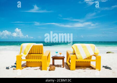 Deux chaises longues jaunes sur la plage de l'hôtel, Tulum, Riviera Maya, Mexique Banque D'Images