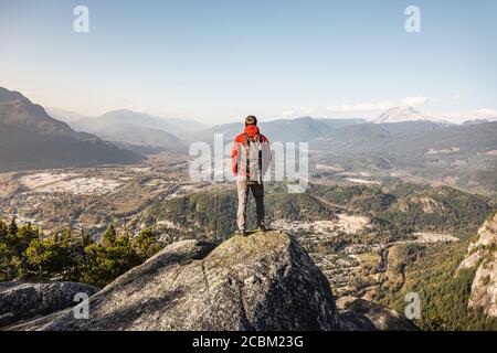 Homme debout en montagne, regardant la vue, Stawamus Chef, surplombant la baie Howe Sound, Squamish, Colombie-Britannique, Canada Banque D'Images