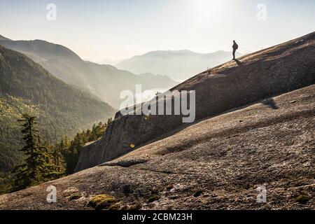 Homme debout en montagne, regardant la vue, Stawamus Chef, surplombant la baie Howe Sound, Squamish, Colombie-Britannique, Canada Banque D'Images