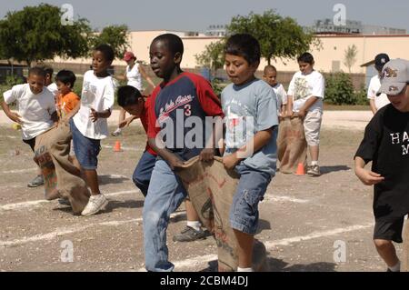 Austin Texas USA, 2006 mai : des garçons de cinquième année participent à une course de sacs à trois pattes sur le terrain de jeu scolaire pendant la « journée de piste et de terrain », qui marque traditionnellement la fin du semestre de printemps dans de nombreuses écoles primaires publiques de la région. ©Bob Daemmrich Banque D'Images