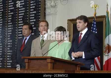 Austin, Texas 25 août 2006 : Gov. Rick Perry, du Texas, parle à la presse en tant que gouverneurs Bill Richardson (à gauche) du Nouveau-Mexique, Arnold Schwarzenegger, de Californie, et Janet Napolitano, de l'Arizona, écoutent la conférence des gouverneurs des frontières au Capitole du Texas. ©Bob Daemmrich Banque D'Images