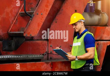 Hommes travailleurs industriels ou ingénieurs vérifiant les processus de machines dans le secteur de la logistique. Banque D'Images