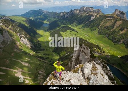 Une femme regarde Sämtisertal depuis le sommet de Fänligipfel (sur Widderalpstöck) à Alpstein, Appenzell Innerrhoden, Suisse. Banque D'Images