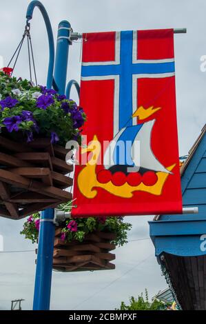 Un lampadaire aux fleurs et le drapeau norvégien à Poulsbo, une ville de Liberty Bay dans le comté de Kitsap, Washington, États-Unis. Banque D'Images