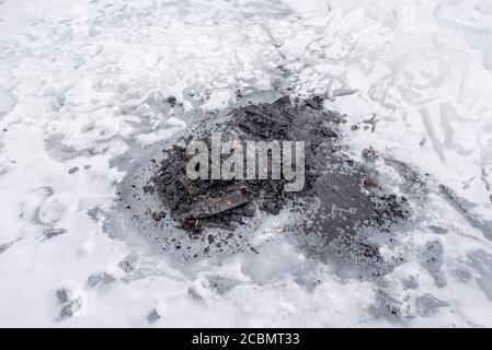 L'ashesh de bois reste du feu de camp sur la glace, lac Baikal, Russie Banque D'Images