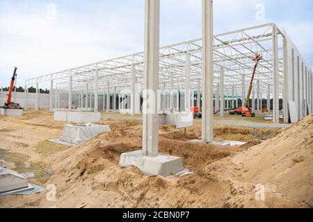 14 août 2020, Brandebourg, Grünheide: Sur le site de construction du futur Gigafactory Berlin-Brandenburg du constructeur automobile américain Tesla, un ouvrier conduit vers le haut de la salle de production pour la fabrication de moteurs avec une plate-forme de levage. (À dpa 'Tesla-Gigalactory se passe avec moins de piles dans l'eau souterraine') photo: Soeren Stache/dpa-Zentralbild/dpa Banque D'Images