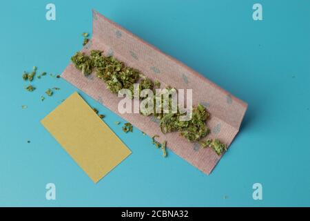 Papier joint pour rouleau de cannabis sur fond bleu vue du dessus, accessoire de tabagisme de marijuana Banque D'Images