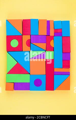 Concepteur pour enfants de formes géométriques 3D volumétriques multicolores sur fond jaune. Jeu éducatif logique. Banque D'Images