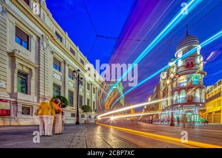 Les sentiers de la lumière d'un tramway sur Constitution Avenue, Séville, Espagne Banque D'Images