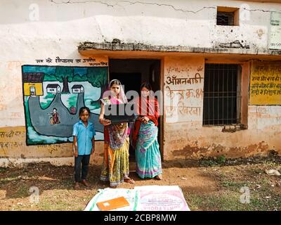 DISTRICT KATNI, INDE - 01 JANVIER 2020 : un professeur du village indien d'Anganwadi tenant un ordinateur portable avec des villageois. Banque D'Images