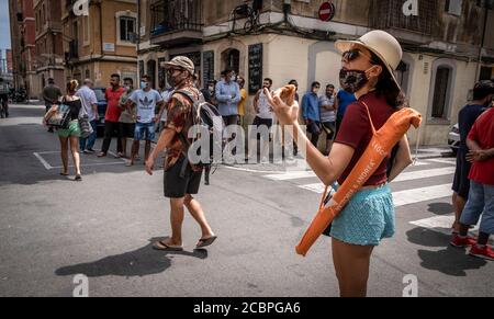 Barcelone, Espagne. 14 août 2020. Un grand groupe de personnes de la communauté pakistanaise se tiennent sur les lieux de l'incendie.trois personnes de la communauté pakistanaise sont mortes après un incendie déclaré dans la maison où elles vivaient. Le feu a éclaté ce matin dans l'un des étages inférieurs d'un bâtiment dans un quartier populaire de Barceloneta quand une des batteries de pédicab a brûlé pendant la charge. Les pédicabs sont des scies électriques pour emmener les touristes autour de la ville. Crédit : SOPA Images Limited/Alamy Live News Banque D'Images