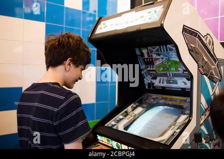 Un adolescent de quinze ans joue au jeu d'arcade Atari Xevious au Musée Computerspiele (musée de jeux vidéo) à Berlin, en Allemagne. Banque D'Images