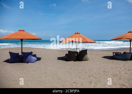 Parasols orange et sacs de haricots vides sur la plage de Berawa (Pantai Berawa), Canggu, Badung, Bali, Indonésie Banque D'Images