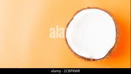 Happy Coconuts Day concept, frais moitié noix de coco, studio tourné isolé sur fond orange Banque D'Images