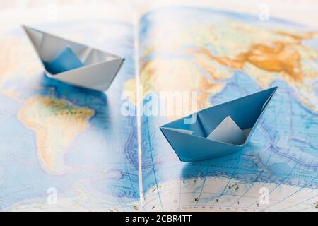 Petits bateaux en papier sur la carte du monde. Concept de voyage ou d'exercice militaire. Banque D'Images