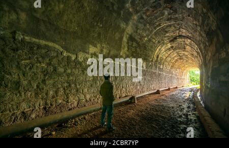 Silhouette voyageur homme exploré dans l'ancien tunnel ferroviaire, abandonné l'architecture du XIXe siècle jusqu'à aujourd'hui près de Da Lat, Vietnam Banque D'Images