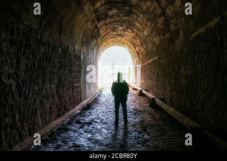 Silhouette voyageur homme exploré dans l'ancien tunnel ferroviaire, abandonné l'architecture du XIXe siècle jusqu'à aujourd'hui près de Da Lat, Vietnam Banque D'Images