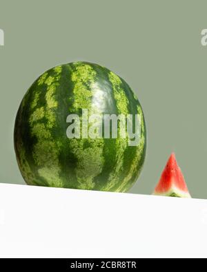 Grande pastèque fraîche et tranche rouge de pastèque sur table sur fond de couleur menthe néo. Concept créatif de fruit d'été minimal. Vue en angle bas Banque D'Images