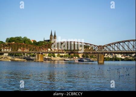 Pont ferroviaire à Vyton sous Vysehrad, Prague, République Tchèque / Tchéquie. Rivière Vltava, remblai avec des personnes non identifiables,. Bâtiment de l'église et Banque D'Images