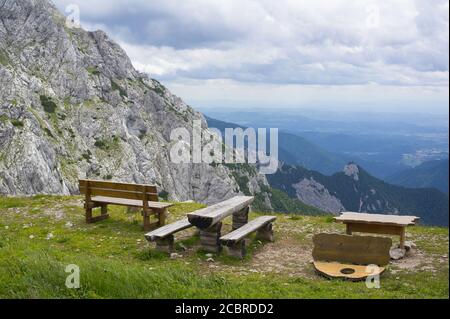 Kamnik selle ( Kamnisko sedlo ), Alpes Kamnik-Savinja, Alpes slovènes, Slovénie, Europe - banquette rustique en bois, table et belle nature avec P rocailleux Banque D'Images