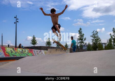 Angers, France - août 15 2020 : un skateur cool en plein air, un gars sautant avec son skate et exécutant un tour au skate Park Banque D'Images