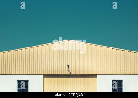 Façade de wharehouse jaune. Bâtiment de stockage fermé dans un parc industriel Banque D'Images