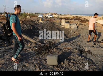 Khan Younis. 15 août 2020. Les Palestiniens inspectent le site d'une frappe aérienne israélienne dans la ville de Khan Younis, dans le sud de la bande de Gaza, le 15 août 2020. Des avions de l'armée israélienne ont frappé vendredi soir des postes et des installations dans la bande de Gaza appartenant à des militants du mouvement islamique du Hamas en réponse au lancement de ballons incendiaires depuis l'enclave côtière vers Israël. Credit: Yasser Qudih/Xinhua/Alay Live News Banque D'Images