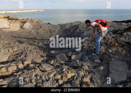 Khan Younis. 15 août 2020. Un palestinien inspecte le site d'une frappe aérienne israélienne dans la ville de Khan Younis, dans le sud de la bande de Gaza, le 15 août 2020. Des avions de l'armée israélienne ont frappé vendredi soir des postes et des installations dans la bande de Gaza appartenant à des militants du mouvement islamique du Hamas en réponse au lancement de ballons incendiaires depuis l'enclave côtière vers Israël. Credit: Yasser Qudih/Xinhua/Alay Live News Banque D'Images