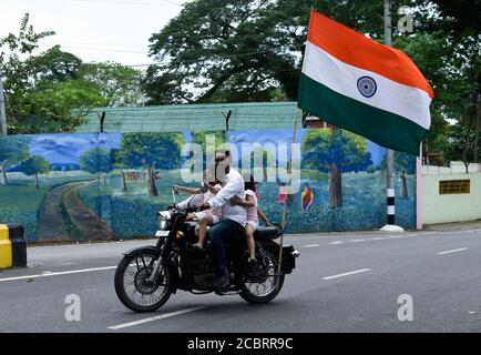 Guwahati, Assam, Inde. 15 août 2020. Un homme avec ses filles porte un masque de vélo alors qu'il célèbre le jour de l'indépendance, dans le cadre de la pandémie COVID-19 en cours, à Guwahati. Crédit : David Talukdar/ZUMA Wire/Alay Live News Banque D'Images