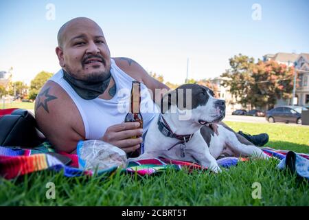 Ce pitbull bénéficie d'un pique-nique au parc Duboce avec son propriétaire à San Francisco, CA, Etats-Unis. Banque D'Images