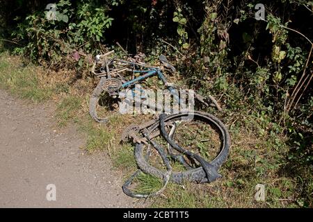 Restes rouillés de vieux vélo sorti du canal Sur le chemin de remorquage Warwick UK Banque D'Images