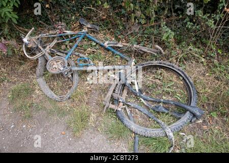 Restes rouillés de vieux vélo sorti du canal Sur le chemin de remorquage Warwick UK Banque D'Images