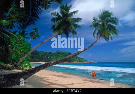 Couple sur la belle plage de sable à Anse Takamaka Sur l'île Mahé aux Seychelles Banque D'Images