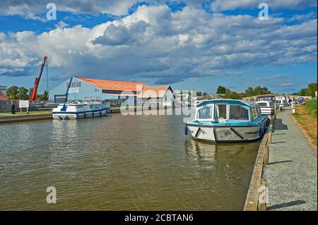 Location de bateaux électriques à l'extérieur d'un quai sur la rivière Thurne à Potter Heigham dans le parc national de Norfolk Broads. Banque D'Images