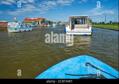 Rive de la rivière Thurne bordée d'une collection originale de cabanes et de maisons d'été à l'approche de Potter Heigham, Norfolk Banque D'Images