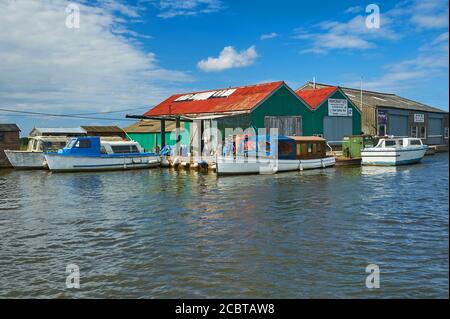 Location de bateaux électriques à l'extérieur d'un quai sur la rivière Thurne à Potter Heigham dans le parc national de Norfolk Broads. Banque D'Images