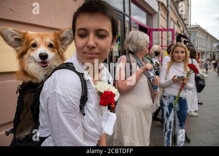 Moscou, Russie. 15 août 2020 UNE femme tenant des fleurs regarde son chien lors d'un rassemblement contre les résultats de l'élection présidentielle biélorusse devant l'ambassade du Bélarus à Moscou, en Russie Banque D'Images