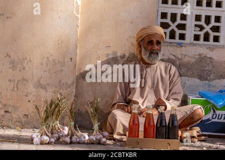 Un homme omanais qui vend du miel et de l'ail au souq de Nizwa Banque D'Images