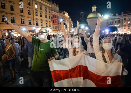 Cracovie, Pologne. 15 août 2020. Les manifestants tiennent des drapeaux de l'opposition biélorusse blancs, rouges et blancs pendant la manifestation. Des centaines de bélarussiens vivant à Cracovie et des supporters locaux se sont réunis lors du rassemblement de solidarité organisé sur la place du marché de Cracovie, à l'extérieur du monument Adam Mickiewicz, contre le leader bélarussien, Alexandre Loukachenko. Crédit : SOPA Images Limited/Alamy Live News Banque D'Images