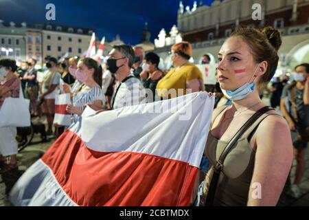 Cracovie, Pologne. 15 août 2020. Les manifestants tiennent des drapeaux de l'opposition biélorusse blancs, rouges et blancs pendant la manifestation. Des centaines de bélarussiens vivant à Cracovie et des supporters locaux se sont réunis lors du rassemblement de solidarité organisé sur la place du marché de Cracovie, à l'extérieur du monument Adam Mickiewicz, contre le leader bélarussien, Alexandre Loukachenko. Crédit : SOPA Images Limited/Alamy Live News Banque D'Images