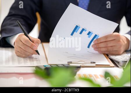 Concept financier et commercial. La main de l'homme d'affaires tenant le graphique financier. Banque D'Images