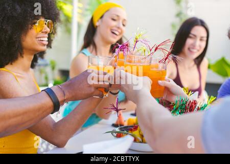 Photo d'un groupe multiracial d'amis qui se mêle à des cocktails - concept d'amitié, de fête et de vacances Banque D'Images