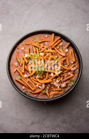 SEV Bhaji ou Shev Sabji ou Kathiyavadi Dhaba style Gathiya nu shaak - curry de tomates épicé, sucré et acidulé recouvert de ganthia ou de gathia croustillantes Banque D'Images