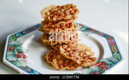 Peyek d'arachide sur la plaque. Cacahuète Rempeyek ou Peyek est un craqueur javanais salé frits à base de farine de riz avec arachides. Banque D'Images