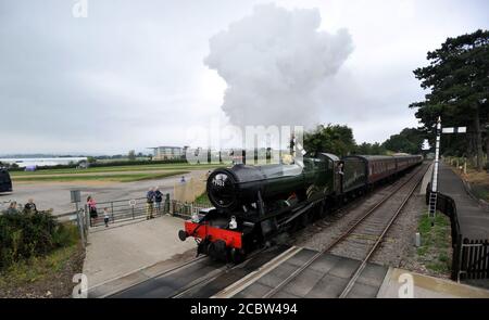 Le moteur sort de la station de Cheltenham avec Cheltenham Racecourse en arrière-plan. Le train à vapeur de Gloucestershire Warwickshire a exécuté son premier tr Banque D'Images