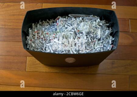 Un déchiqueteuse de papier plein de papier déchiqueté dans un bureau à la maison. Banque D'Images