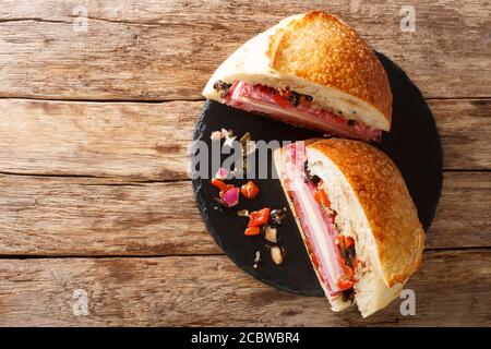 Sandwich Muffaletta avec pain maison et salade d'olives en gros plan un tableau en ardoise sur la table, vue horizontale du dessus à partir de ci-dessus Banque D'Images